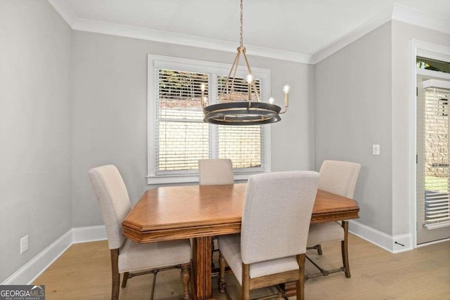 dining room featuring a notable chandelier, light wood-type flooring, plenty of natural light, and crown molding