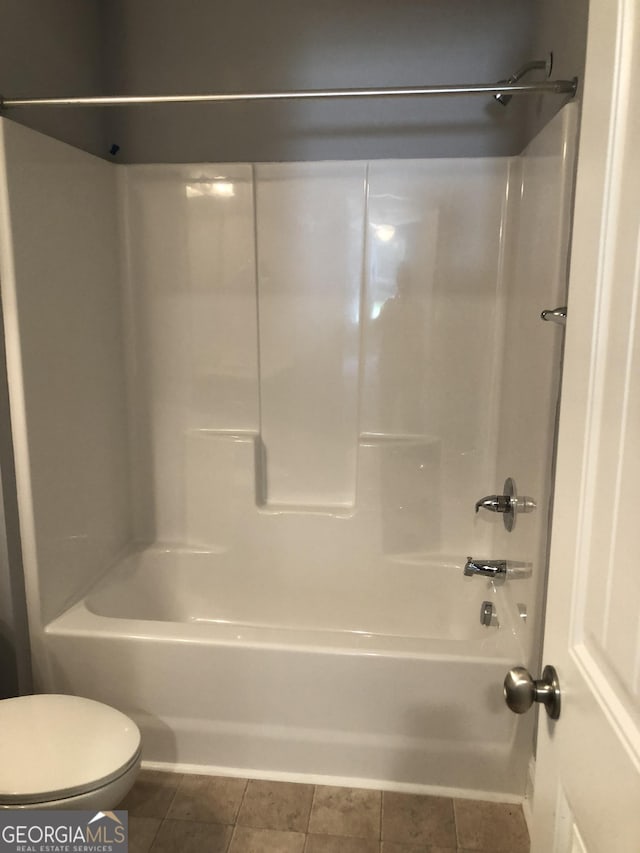 bathroom featuring shower / bathing tub combination, tile patterned floors, and toilet