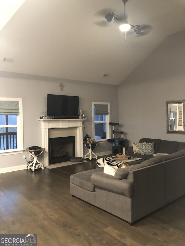 living room with lofted ceiling, hardwood / wood-style flooring, a tile fireplace, and ceiling fan