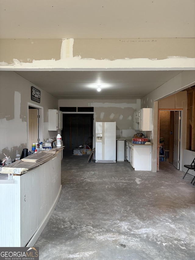 garage featuring white fridge with ice dispenser