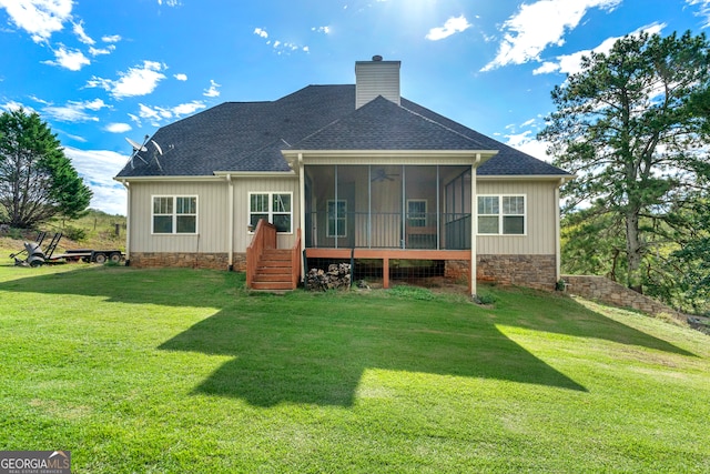 back of property with a sunroom and a yard