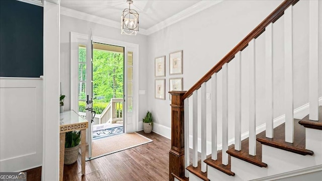 entryway with ornamental molding, a chandelier, and hardwood / wood-style flooring