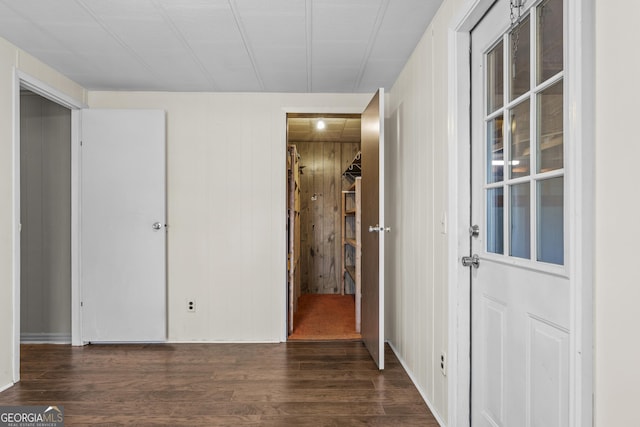 unfurnished bedroom featuring dark hardwood / wood-style floors and wooden walls