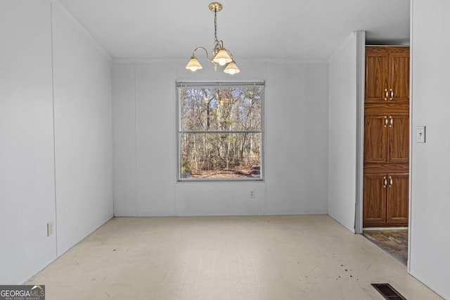 unfurnished dining area with a chandelier and ornamental molding