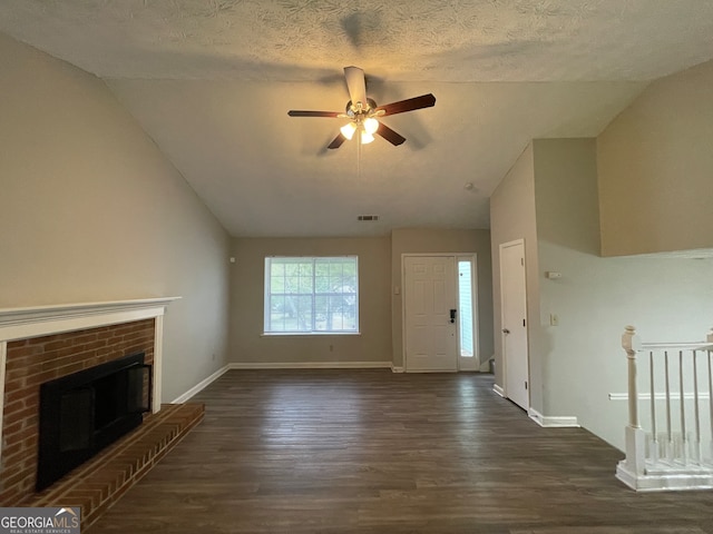 unfurnished living room with a textured ceiling, vaulted ceiling, and dark hardwood / wood-style flooring