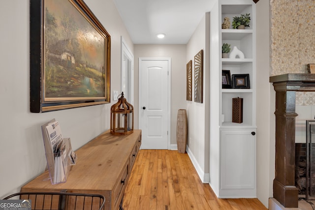 hall featuring light hardwood / wood-style flooring and built in features