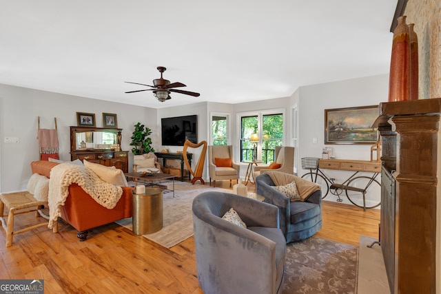 living room with light hardwood / wood-style floors and ceiling fan