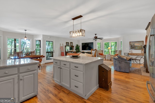 kitchen with light hardwood / wood-style flooring, a center island, pendant lighting, and plenty of natural light