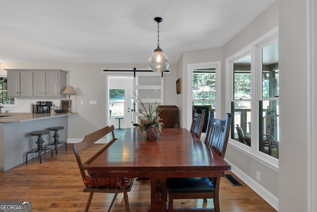 dining room featuring a barn door and hardwood / wood-style floors