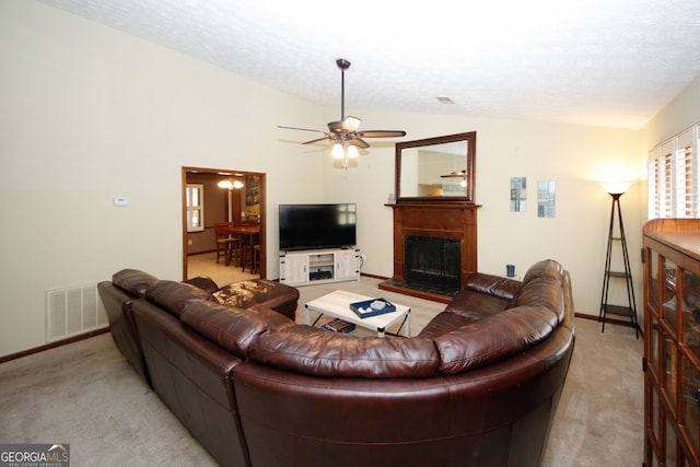 living room featuring light carpet, a textured ceiling, ceiling fan, and vaulted ceiling