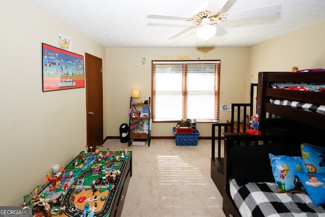 bedroom featuring a textured ceiling, light colored carpet, and ceiling fan