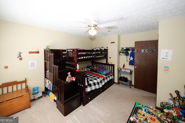 carpeted bedroom featuring a textured ceiling and ceiling fan