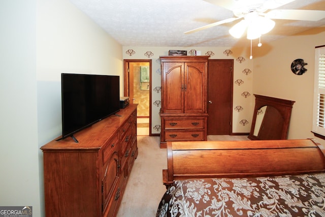 bedroom featuring a textured ceiling, light colored carpet, and ceiling fan