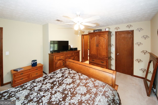 carpeted bedroom featuring a textured ceiling and ceiling fan