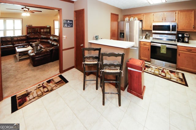 kitchen featuring ceiling fan, stainless steel appliances, and light tile patterned floors