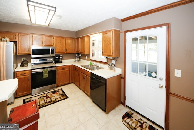 kitchen featuring a textured ceiling, stainless steel appliances, and sink