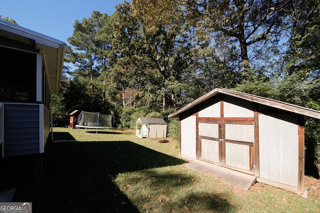 view of yard with a storage shed and a trampoline