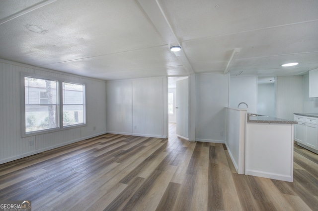 unfurnished living room featuring hardwood / wood-style flooring and sink