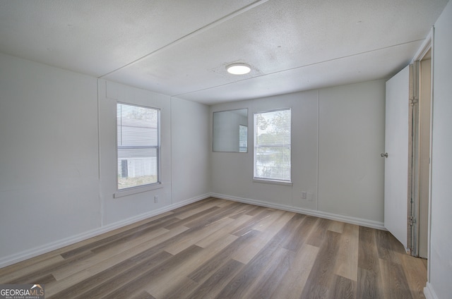 unfurnished room featuring a textured ceiling and hardwood / wood-style floors