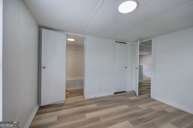 unfurnished bedroom featuring light hardwood / wood-style floors and a spacious closet