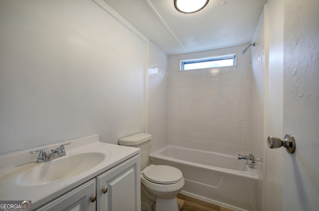 full bathroom with vanity, a textured ceiling, tiled shower / bath combo, wood-type flooring, and toilet