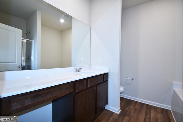 full bathroom featuring plus walk in shower, vanity, hardwood / wood-style floors, and toilet