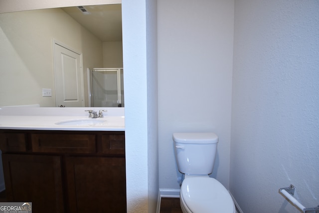 bathroom with vanity, toilet, and an enclosed shower