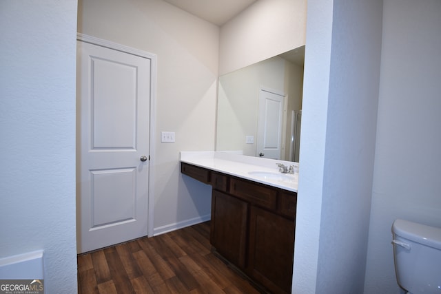 bathroom featuring wood-type flooring, vanity, and toilet