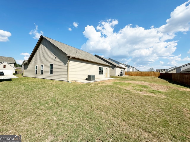 back of house with a yard and central AC