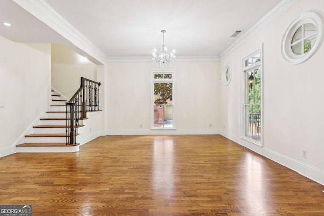 interior space with hardwood / wood-style flooring, crown molding, and an inviting chandelier