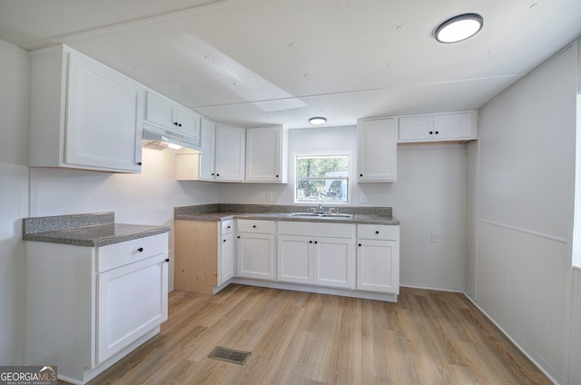 kitchen with light wood-type flooring, sink, and white cabinets