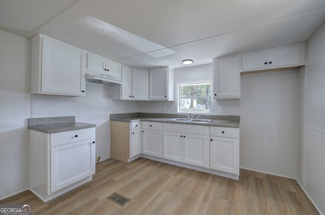 kitchen featuring white cabinets, light hardwood / wood-style floors, and sink