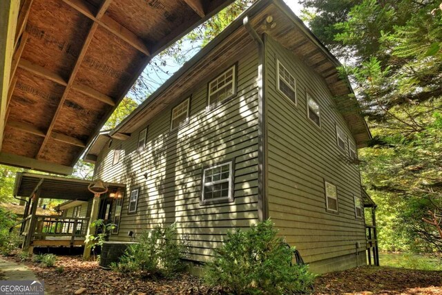 view of side of property featuring cooling unit and a wooden deck