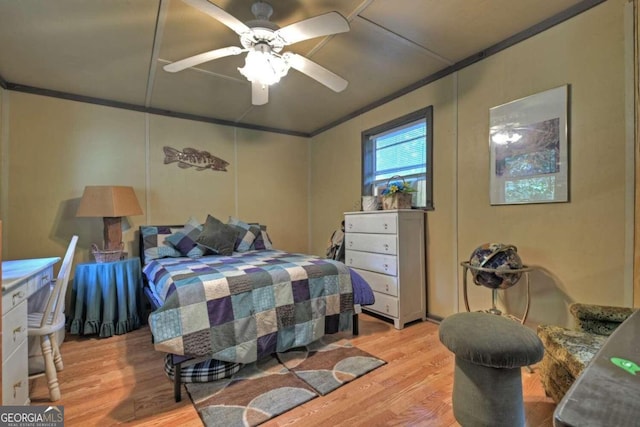 bedroom featuring light hardwood / wood-style floors, ornamental molding, and ceiling fan