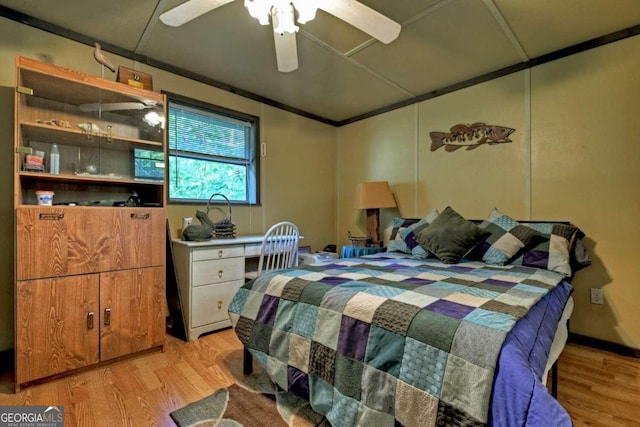 bedroom featuring ceiling fan, light wood-type flooring, and ornamental molding