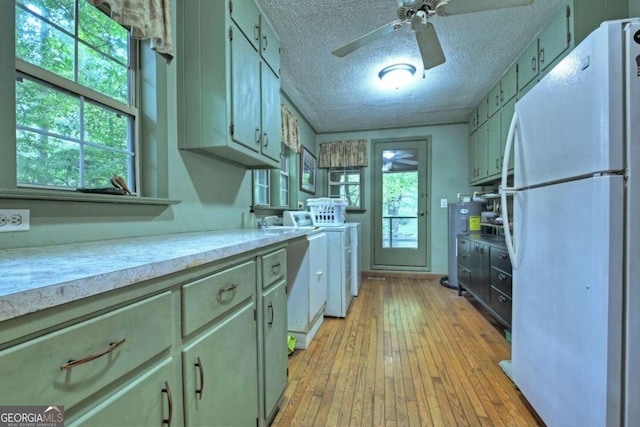 kitchen with light wood-type flooring, a textured ceiling, white fridge, and ceiling fan