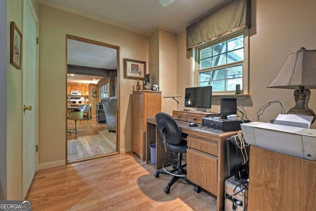 office area with light hardwood / wood-style floors and crown molding