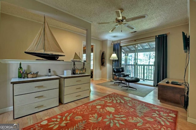 interior space with a textured ceiling, light hardwood / wood-style floors, and ceiling fan