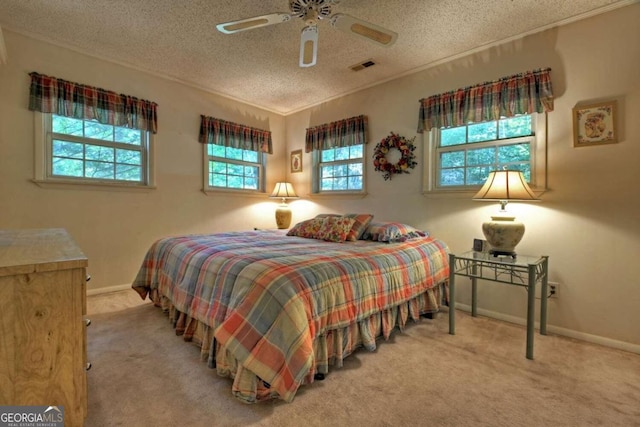 carpeted bedroom featuring multiple windows, a textured ceiling, and ceiling fan