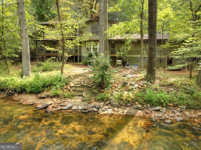 view of yard featuring a water view and a sunroom