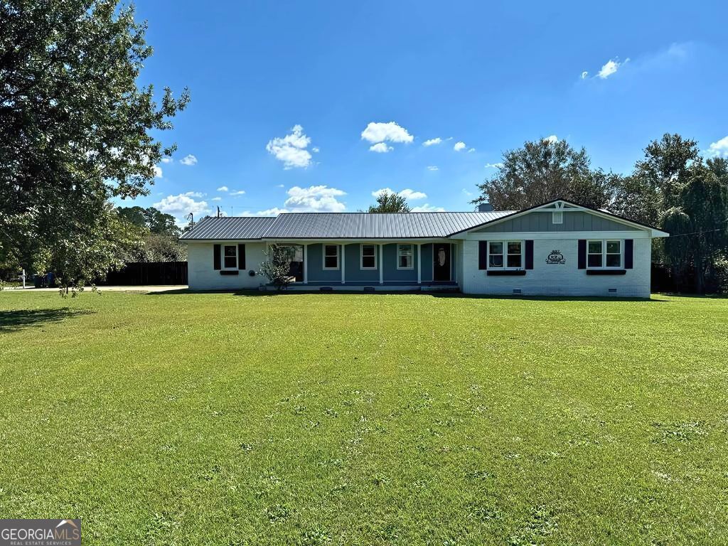 single story home featuring a front lawn