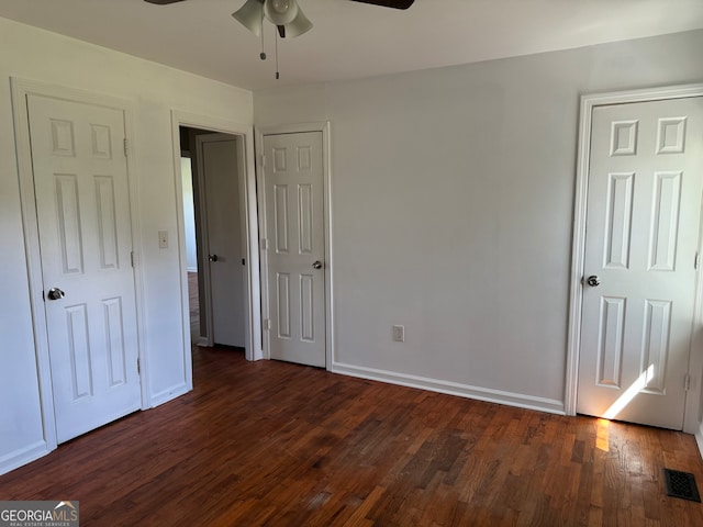 unfurnished bedroom featuring ceiling fan and dark hardwood / wood-style flooring