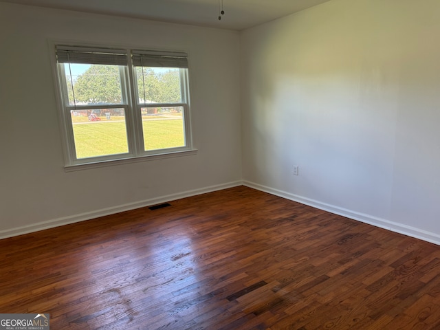 spare room featuring ceiling fan and dark wood-type flooring