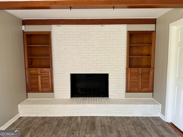 unfurnished living room with wood walls, a fireplace, and dark hardwood / wood-style flooring