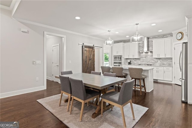 dining area with crown molding, a barn door, and dark hardwood / wood-style floors