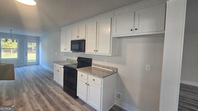 kitchen with black appliances, white cabinets, and stone counters