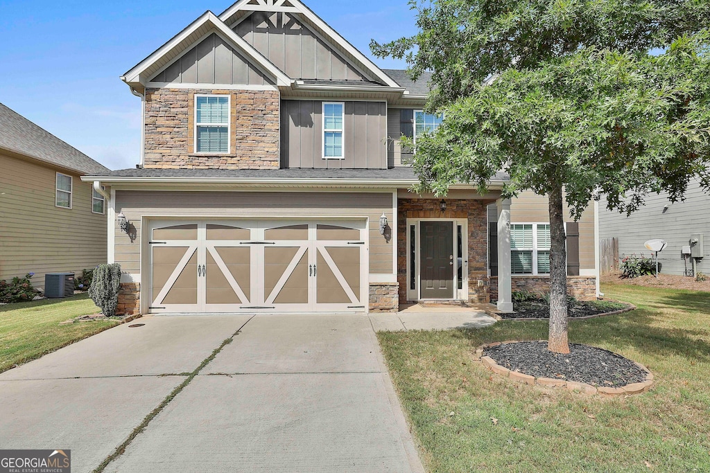 craftsman-style home featuring a garage, central AC unit, and a front lawn