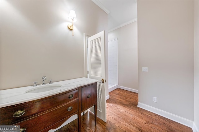 bathroom featuring crown molding, vanity, and hardwood / wood-style floors