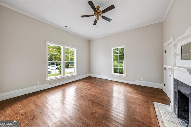 unfurnished living room with ornamental molding, hardwood / wood-style floors, ceiling fan, and a premium fireplace