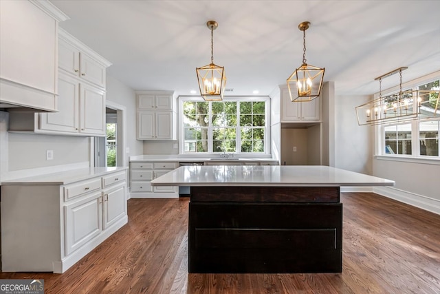 kitchen with hanging light fixtures, a center island, dark wood-type flooring, and white cabinets